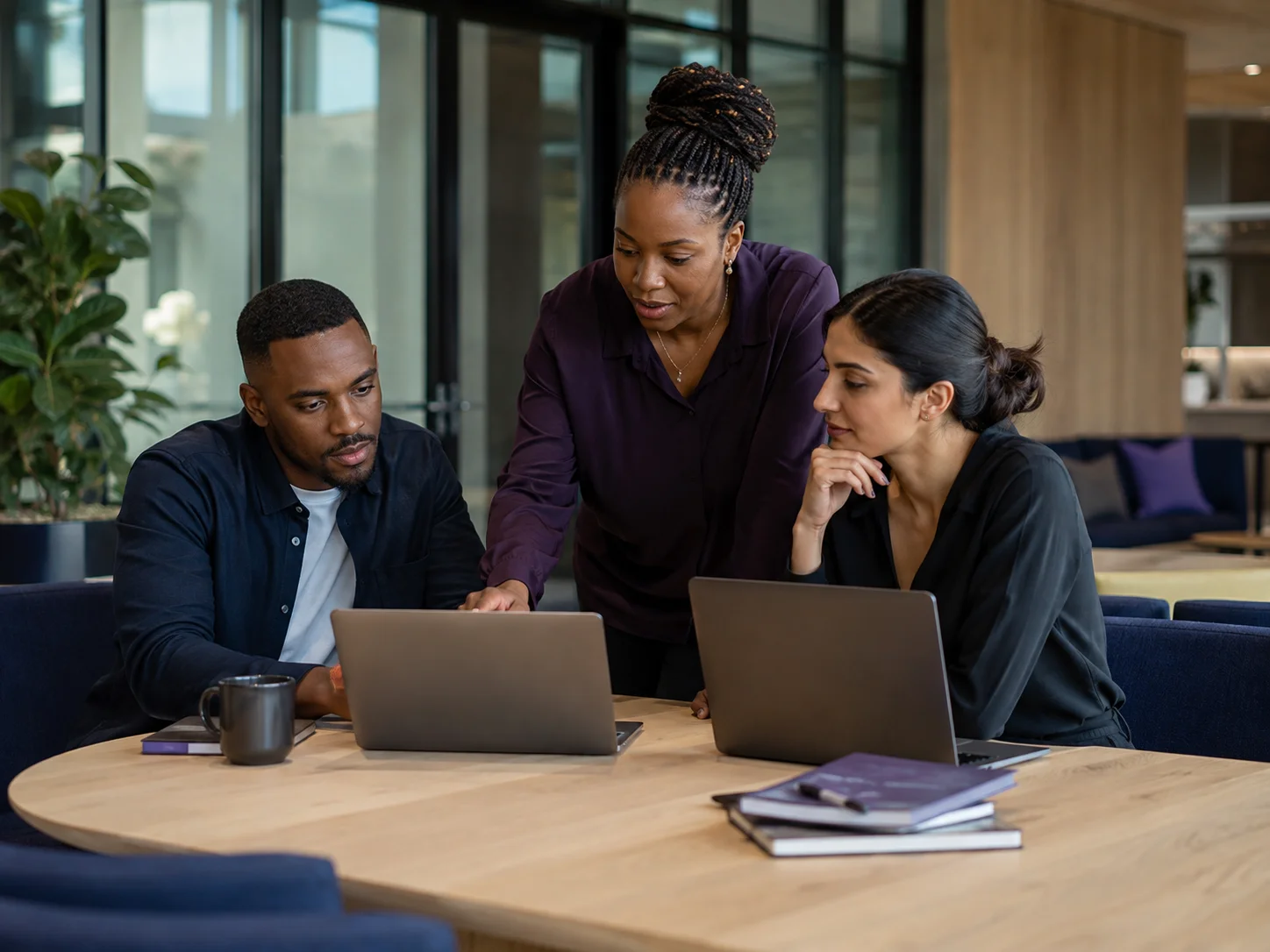 Illustrative studio scene of three professionals collaborating on a digital project